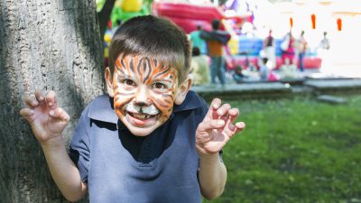 A young boy with his face painted like a tiger