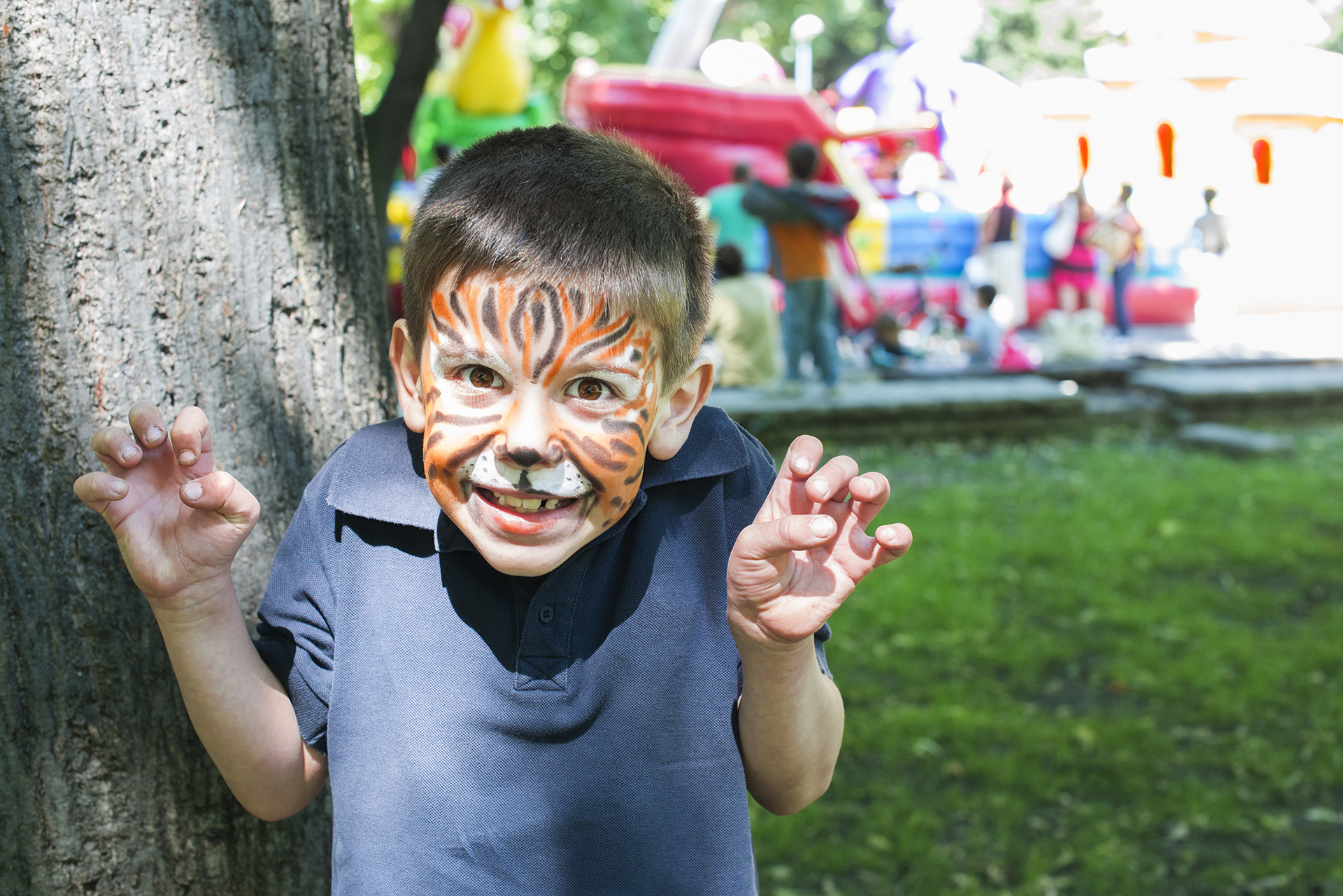 A young boy with his face painted like a tiger