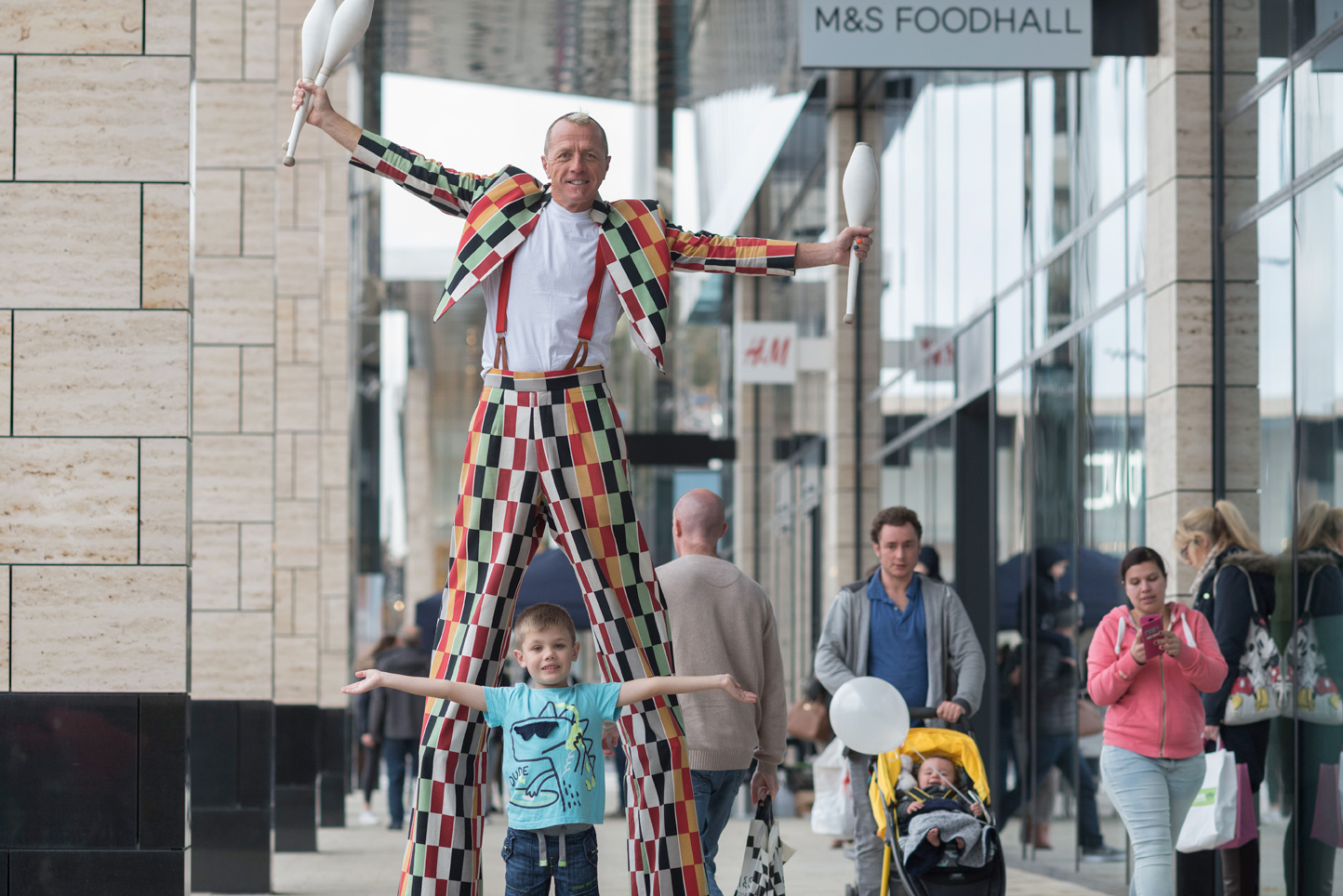 Clown on stilts shopping at retail park in Leeds